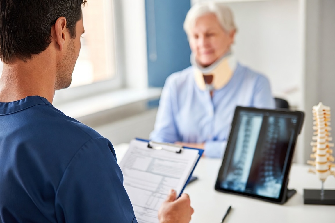 Car accident injury doctor examining a patient's neck for whiplash in Manhattan